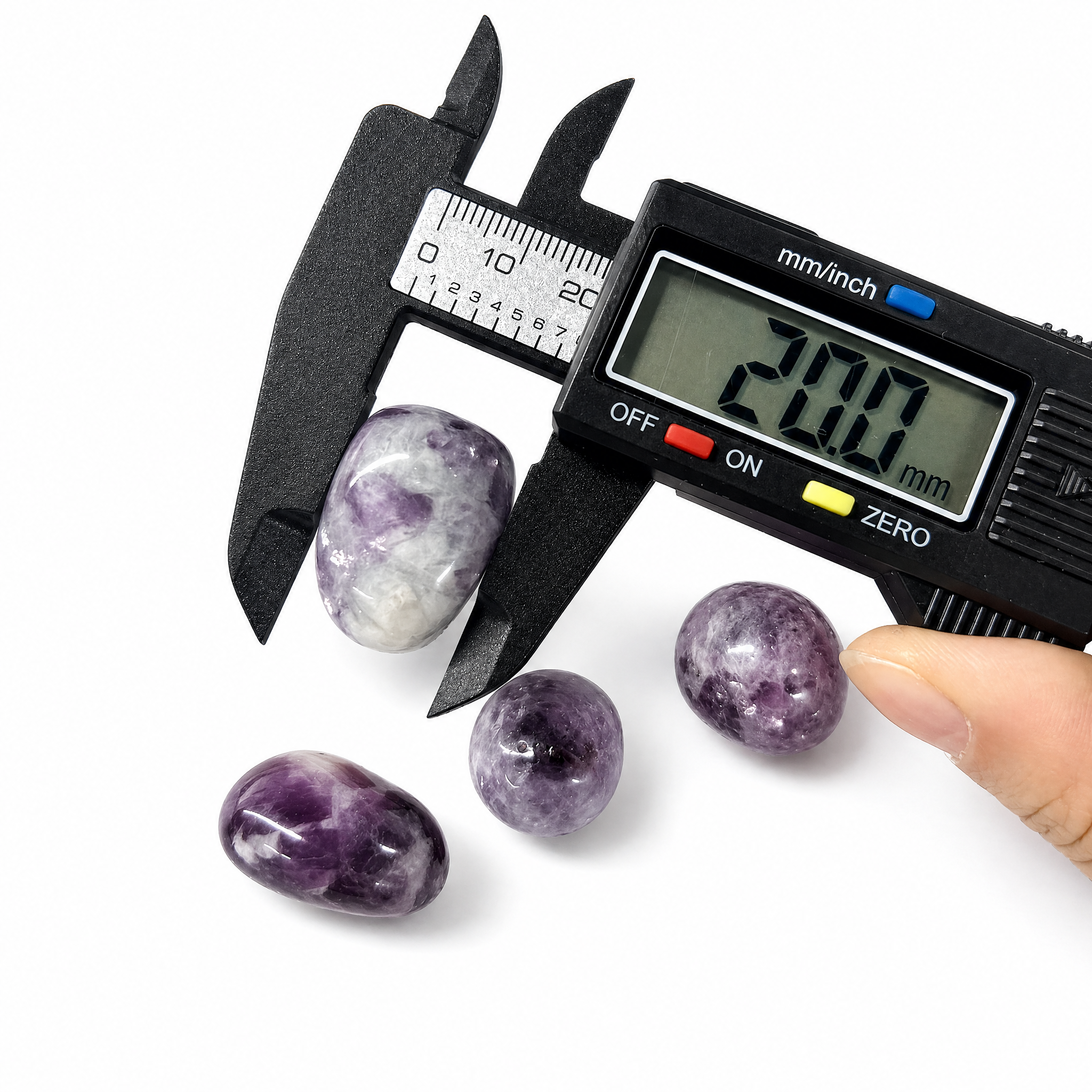 Hand-selected Phosphosiderite tumbled stones being measured with a digital caliper, showing size approximately 18mm to 22mm, premium quality healing crystals from VoraZen.