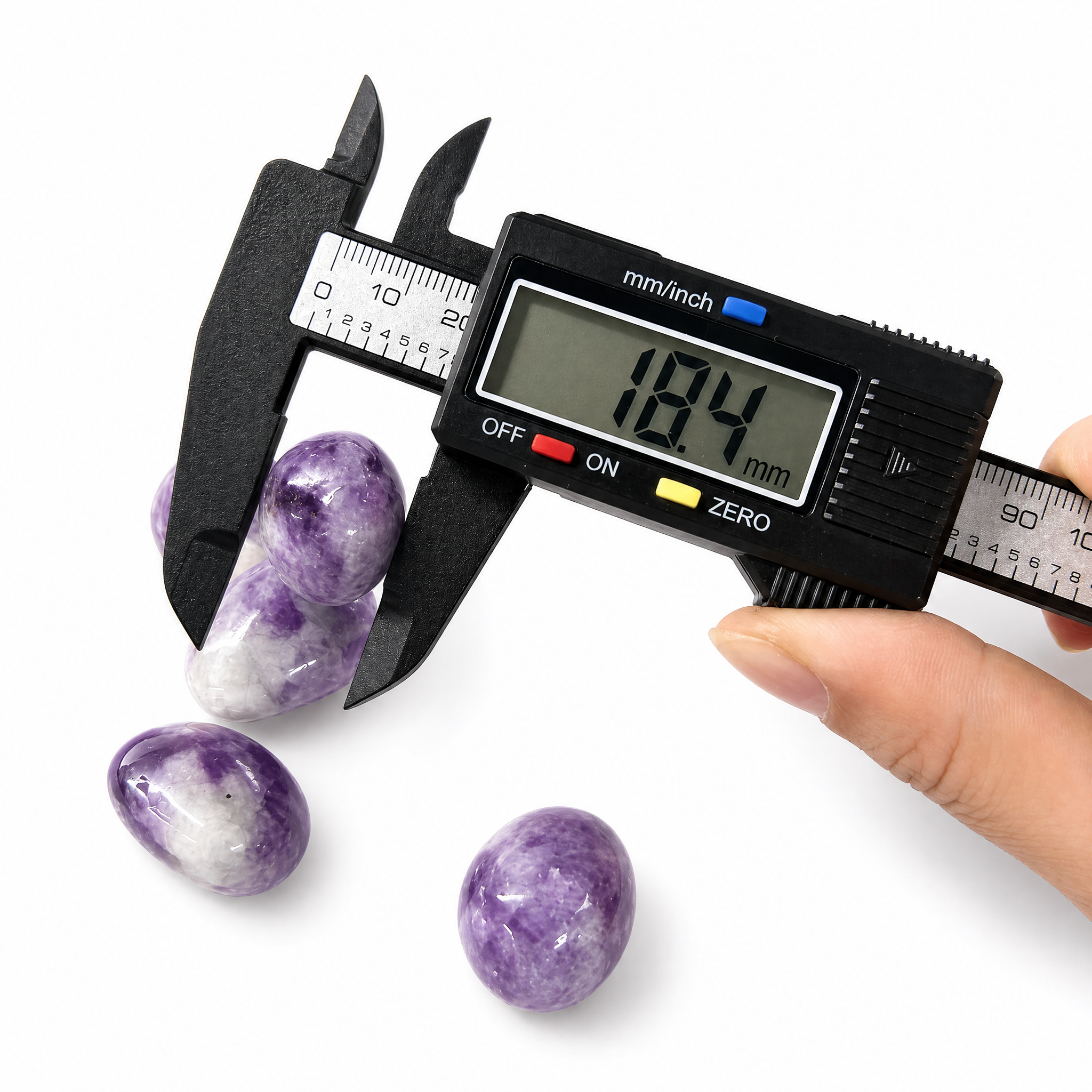 Hand-selected Phosphosiderite tumbled stones being measured with a digital caliper, showing size approximately 18mm to 22mm, premium quality healing crystals from VoraZen.