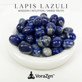 VoraZen™ Premium Natural Lapis Lazuli Tumbled Stones in a white porcelain bowl. These deep royal blue healing crystals feature golden pyrite flecks, known for Wisdom and Truth. High-quality polished finish, perfect for meditation and spiritual growth.