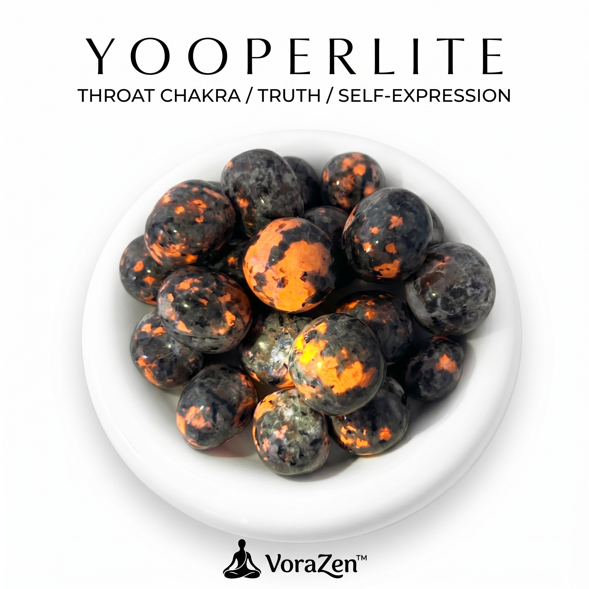 VoraZen™ Glowing Yooperlite Tumbled Stones in a white bowl. These unique Syenite stones contain fluorescent Sodalite that glows like fiery lava under UV light. Natural grey stones by day, glowing orange embers by night. High-quality polished finish for crystal collectors.